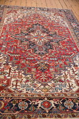 Vintage Heriz carpet's navy samovar border motif and cherry red geometric field.