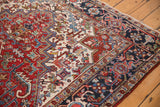 Navy border with reciprocating turtle motifs and low pile of a vintage Heriz rug.