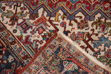 Heriz carpet folded corner, cherry red and ivory geometric pile, white fringe, hand-knotted back.