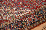 Ivory floral field meets navy border with reciprocating samovar motif on vintage Heriz carpet.