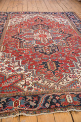 Secured fringe and intricate navy border design of a vintage Heriz rug.