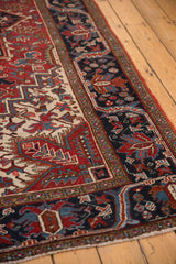 Vintage Heriz carpet's distinct navy blue border and geometric floral red, ivory field.