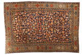 Vintage Heriz carpet with navy field, allover vinery, floral blossoms, and geometric border.