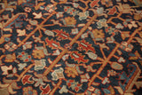 Hand-knotted Heriz carpet detail showing vinery, floral blossoms, and buds in navy, gold, and red.