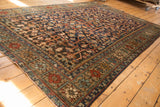 Unusual border with red, blue, and ivory floral motifs on a vintage Heriz carpet corner.