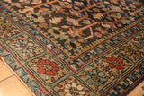 Traditional Heriz carpet border with alternating red, blue, and beige floral motifs.