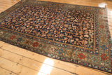 Vintage Heriz Persian rug close-up: unusual border with alternating floral panels, deep navy vinery field.