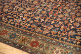 Vintage Heriz carpet detail: navy field, dusty gold vinery, cherry red, and blue border motifs.