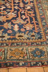 Detail of vintage Heriz carpet: navy geometric field, unusual floral square border, light wear visible.