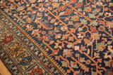 Vintage Heriz carpet: unusual border, alternating floral panels, and navy vinery field.