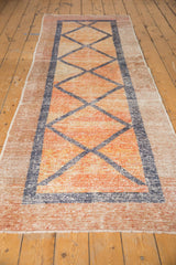 Distressed vintage Oushak runner, central diamonds in faded blue on blush and raspberry.