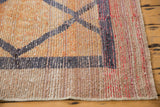 Distressed Oushak runner's worn pile, visible foundation, and geometric border pattern in raspberry red, beige, dark gray.