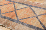 Distressed Oushak runner, geometric diamond outlines in blush, raspberry, beige, and silver.