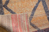 Vintage distressed Oushak rug showing low pile texture and woven red striped foundation.