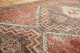 Distressed Oushak runner's zig-zag geometric pattern showing cherry red and charcoal tones.