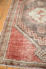 Textured cherry red field with stepped charcoal and beige geometric contour on the vintage Oushak.