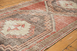 Textured pile and stepped geometric motifs in cherry red and charcoal on a distressed Oushak runner.