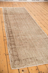 Distressed texture of a vintage Oushak runner with tone-on-tone beige and sand hues.