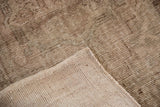 Distressed Oushak rug pile with even wear, hand-knotted beige foundation, and intact selvage.