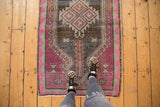 Vintage distressed Oushak rug with abrashed field, serrated medallion, and blush pink motifs.