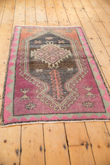Distressed Turkish Oushak rug with blush abrashed field, charcoal geometric patterns, and pink border.