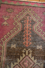 Distressed Oushak rug: blush pink serrated medallion, abrashed charcoal field, and germinating plant motif.