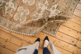 Textured vintage distressed Oushak rug with an abrashed field in muted earthy tones.