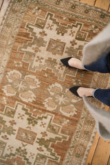 Distressed vintage Oushak rug showcasing its abrashed field and geometric floral pattern.
