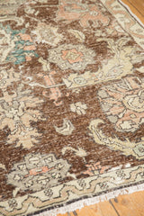 Worn brown, beige, pale rose, and teal palmette motifs on a distressed vintage Sparta rug.