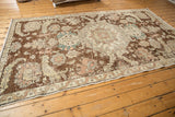 Distressed vintage Turkish Sparta rug featuring plum field, beige border, and sprawling palmette motifs.