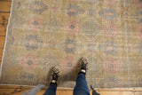 Distressed vintage Oushak rug texture with blush pink, slate silver floral motifs.