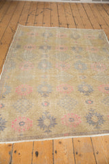 Distressed Oushak rug: splayed floral motifs in lattice, blush pink, dusty slate silver.