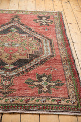 Distressed cherry red field and geometric medallion detail on a vintage Oushak rug.