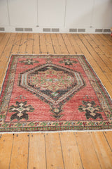 Distressed cherry red pile, showing even wear and secured fringe of the Oushak rug.