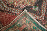 Vintage Distressed Oushak rug reverse showing foundation, fringe, and worn pile with red, green, black.