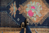 Vibrant pink, powder blue, and copper floral motifs on distressed Oushak rug.