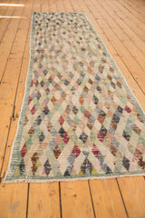 Distressed multi-color diamond pattern and frayed fringe on the Oushak rug end.