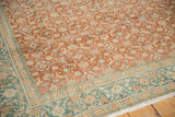 Distressed Sivas rug with terracotta Herati motif field and dusty teal floral border.