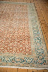 Distressed vintage Sivas carpet corner with terracotta Herati field and dusty teal border.