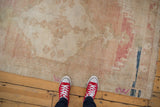 Distressed Oushak runner's low pile with ivory, blush, and faint indigo abrasions.