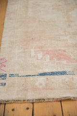 Low pile texture on distressed Oushak runner, with abrashed ivory, blush, indigo, and short fringe.
