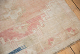 Distressed vintage Oushak runner with low pile, abrashed blush, ivory, and indigo detail.