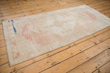 Distressed vintage Oushak runner showcasing its soft ivory and blush abrashed field.