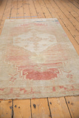 Distressed vintage Oushak runner's blush abrashed low pile and fringed end.