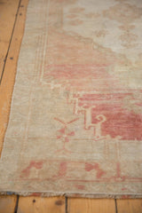 Vintage Oushak rug runner's secured side, showing low pile abrash and blush tones.