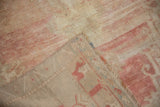 Distressed low pile surface and hand-knotted beige foundation of the vintage Oushak rug.
