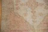 Distressed Oushak runner detail: low pile texture, soft blush and ivory hues, faded geometric motifs.