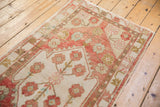 Oversized floral motifs in blush, ivory, and gold on a distressed vintage Oushak rug.