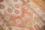 Textured blush and ivory Oushak runner pile with dusty gold and muted blue floral motifs.