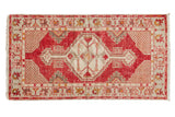 Distressed vintage Oushak runner with a cherry red field and ivory diamond medallion.